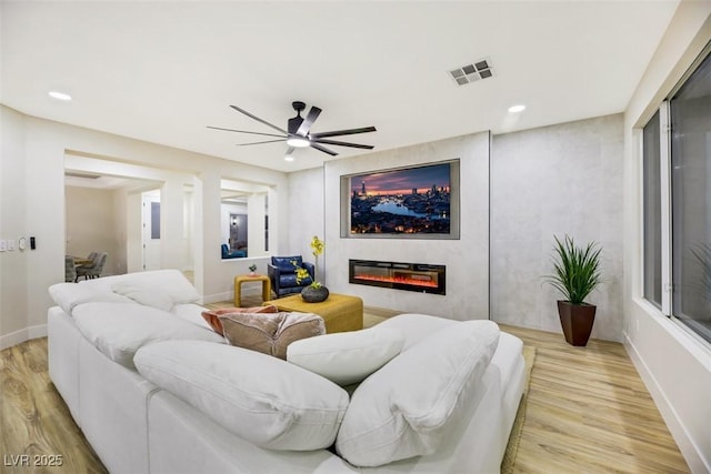 living room with ceiling fan and light wood-type flooring