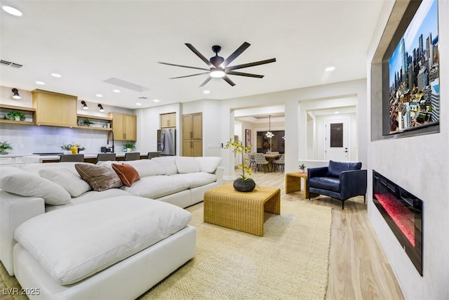 living room featuring light hardwood / wood-style flooring and ceiling fan