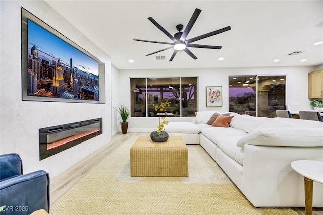 living room with ceiling fan and light hardwood / wood-style flooring