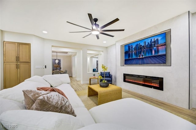 living room with light hardwood / wood-style flooring and ceiling fan