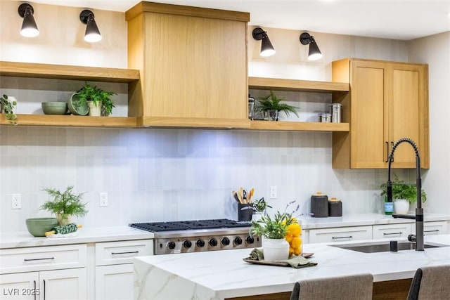 kitchen with white cabinetry, light brown cabinets, tasteful backsplash, sink, and light stone counters