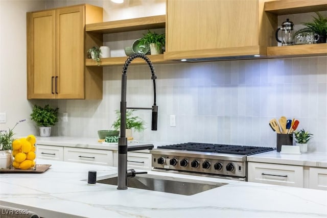 kitchen with backsplash, white cabinets, and light stone countertops