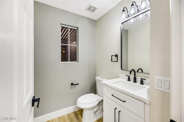 bathroom featuring vanity, toilet, and wood-type flooring