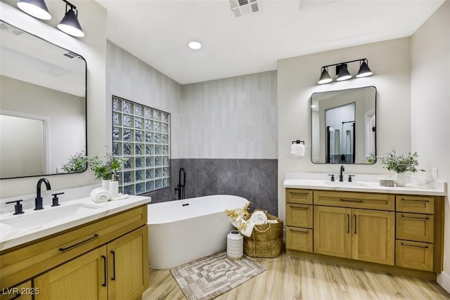 bathroom featuring vanity, a tub, tile walls, and hardwood / wood-style floors