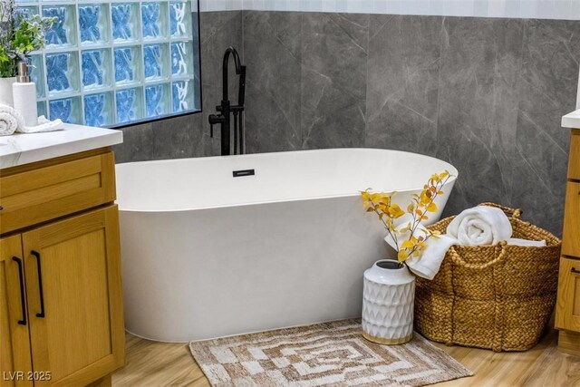 bathroom featuring wood-type flooring, vanity, and a bathtub