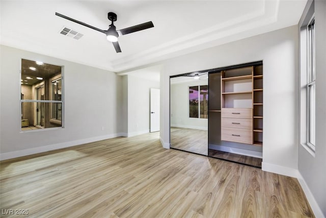 unfurnished bedroom with ceiling fan, a closet, and light wood-type flooring