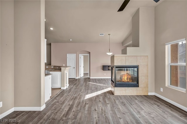 unfurnished living room featuring light wood-type flooring, sink, and a fireplace