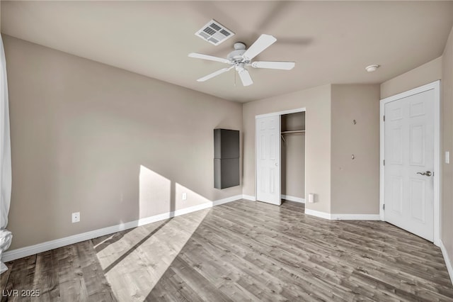 unfurnished bedroom featuring hardwood / wood-style floors, ceiling fan, and a closet