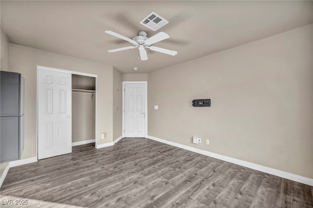 unfurnished bedroom with ceiling fan, a closet, and light hardwood / wood-style flooring