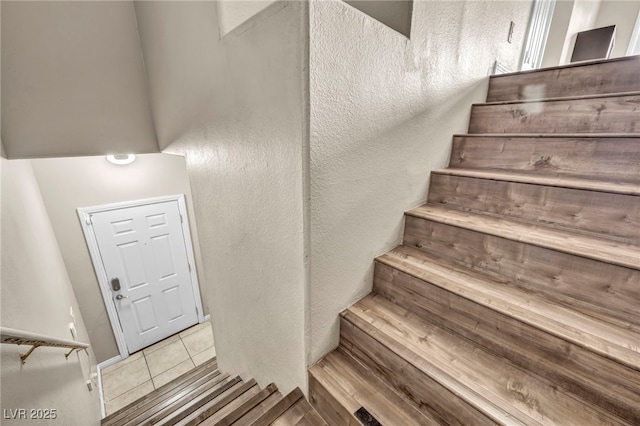 staircase featuring tile patterned flooring