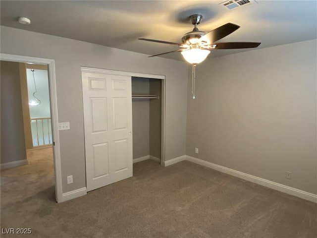 unfurnished bedroom featuring ceiling fan, a closet, and dark colored carpet