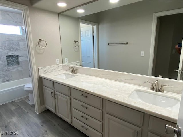 full bathroom featuring vanity, hardwood / wood-style flooring, tub / shower combination, and toilet