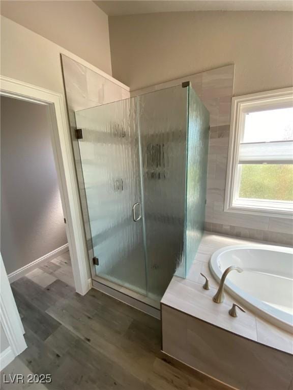 bathroom featuring hardwood / wood-style flooring and plus walk in shower