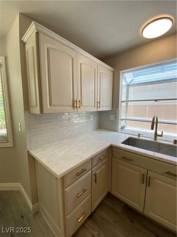 kitchen featuring sink, backsplash, dark hardwood / wood-style floors, and plenty of natural light