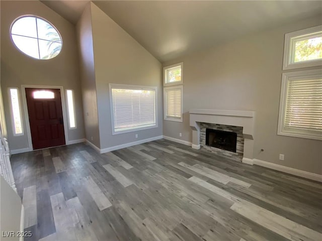 entrance foyer featuring hardwood / wood-style flooring, high vaulted ceiling, and a fireplace