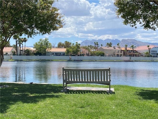 dock area with a yard and a water and mountain view