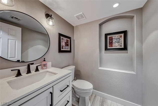 bathroom with hardwood / wood-style floors, toilet, and vanity