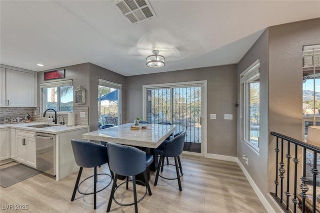 dining space with sink and light hardwood / wood-style floors