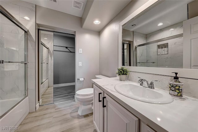 full bathroom with vanity, toilet, and bath / shower combo with glass door