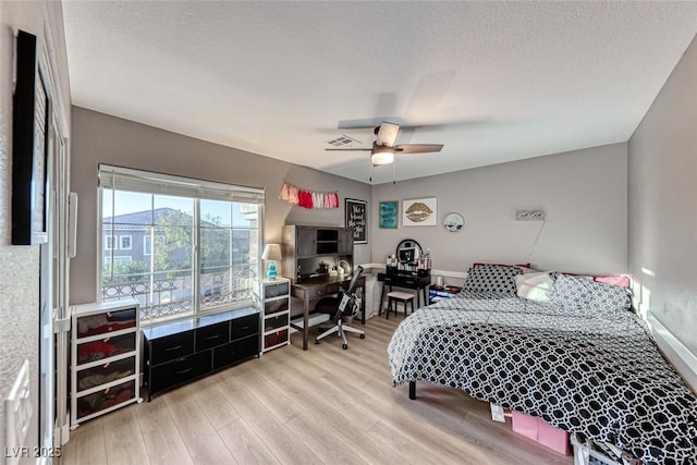 bedroom with ceiling fan, a textured ceiling, and wood-type flooring