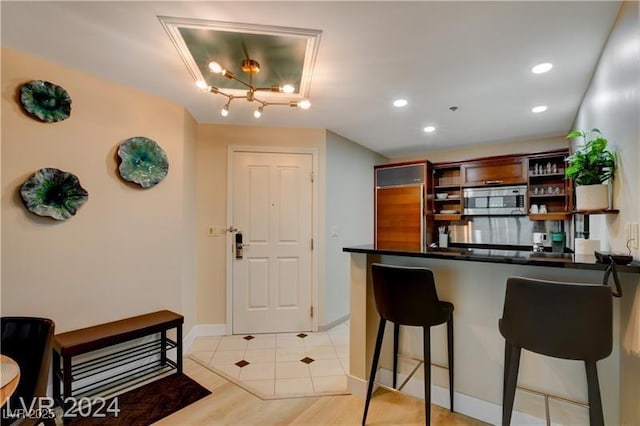 kitchen featuring light hardwood / wood-style floors, kitchen peninsula, and a breakfast bar area