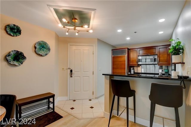 kitchen featuring kitchen peninsula, light hardwood / wood-style flooring, and a kitchen bar