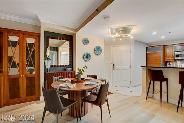 dining room featuring light wood-type flooring and ornamental molding