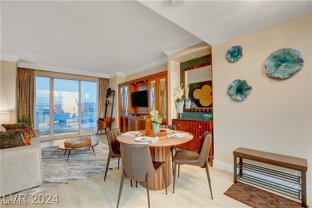 dining space with light hardwood / wood-style floors and ornamental molding