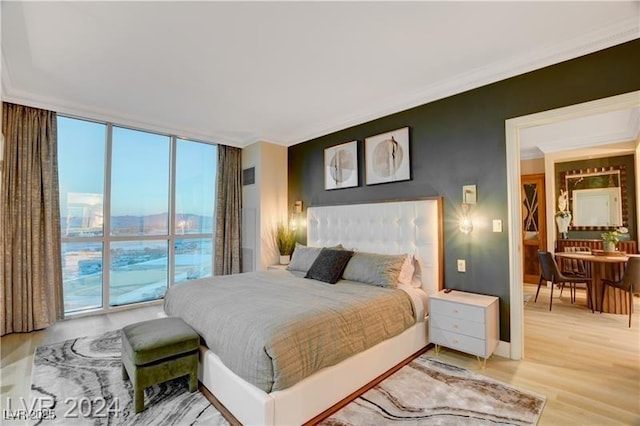 bedroom featuring a wall of windows, access to exterior, hardwood / wood-style floors, and crown molding