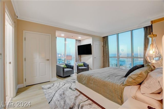 bedroom with crown molding and light wood-type flooring