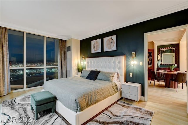 bedroom featuring hardwood / wood-style flooring, ornamental molding, and floor to ceiling windows