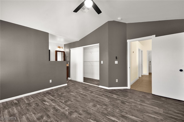 unfurnished room with ceiling fan, dark wood-type flooring, and lofted ceiling