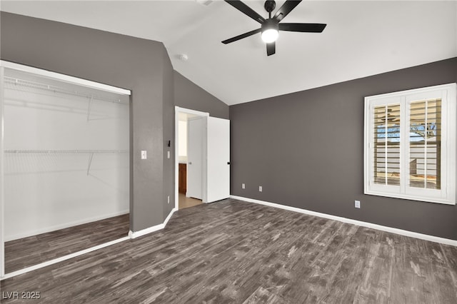 unfurnished bedroom featuring lofted ceiling, dark hardwood / wood-style floors, a closet, and ceiling fan