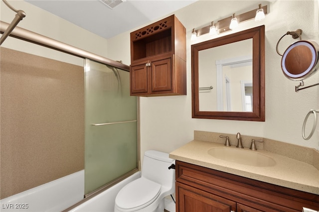 full bathroom with vanity, toilet, and bath / shower combo with glass door