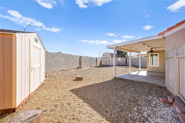 view of yard featuring ceiling fan, a patio area, and a storage shed