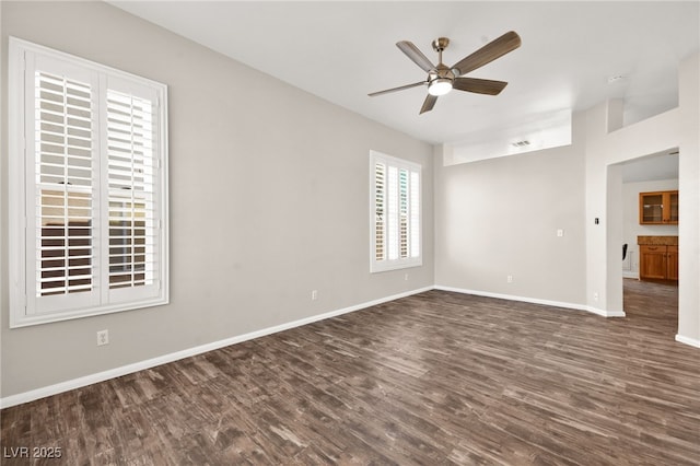 unfurnished room with dark wood-type flooring and ceiling fan