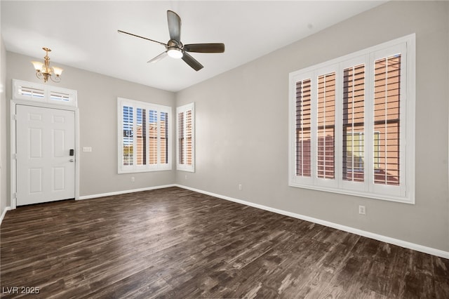 entryway with ceiling fan with notable chandelier, plenty of natural light, and dark hardwood / wood-style floors