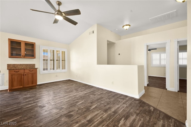 unfurnished living room featuring ceiling fan, dark hardwood / wood-style floors, and lofted ceiling