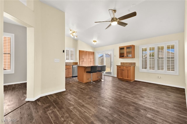 kitchen featuring dishwasher, a center island, a kitchen bar, dark hardwood / wood-style floors, and lofted ceiling