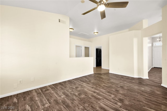 spare room with dark wood-type flooring, ceiling fan with notable chandelier, and lofted ceiling