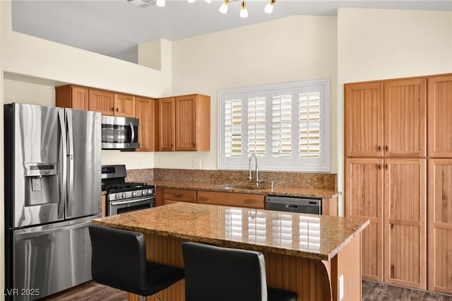 kitchen featuring light stone counters, sink, a kitchen breakfast bar, and stainless steel appliances