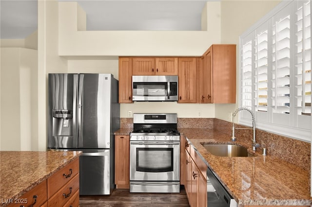 kitchen with sink, stainless steel appliances, a wealth of natural light, and light stone countertops