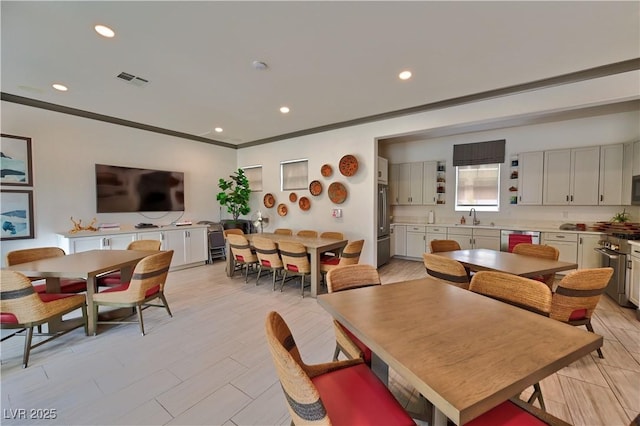 dining area with ornamental molding and sink