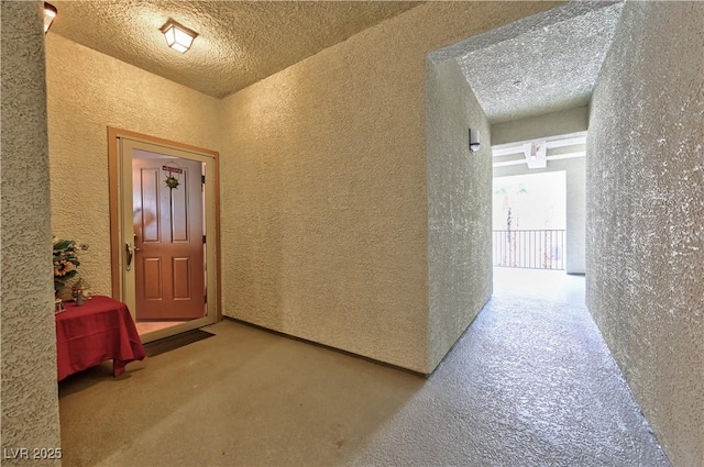 hall featuring a textured ceiling