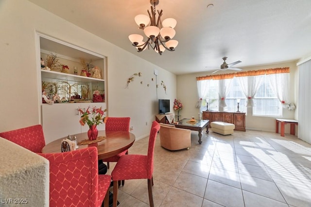 tiled dining room with ceiling fan with notable chandelier and built in shelves