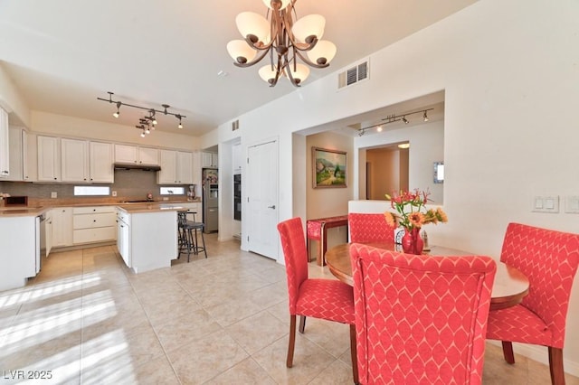 tiled dining area with sink and a notable chandelier