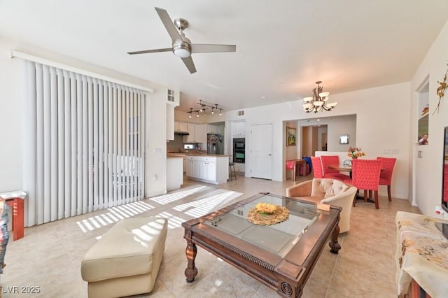 living room with ceiling fan with notable chandelier and light tile patterned floors