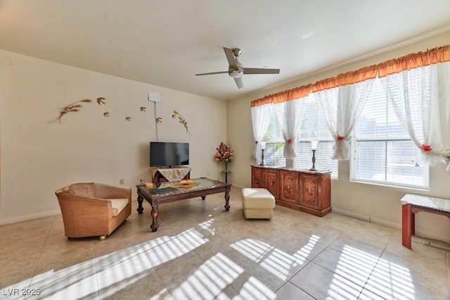 living area with light tile patterned flooring, ceiling fan, and a healthy amount of sunlight