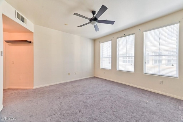 carpeted spare room with a healthy amount of sunlight and ceiling fan