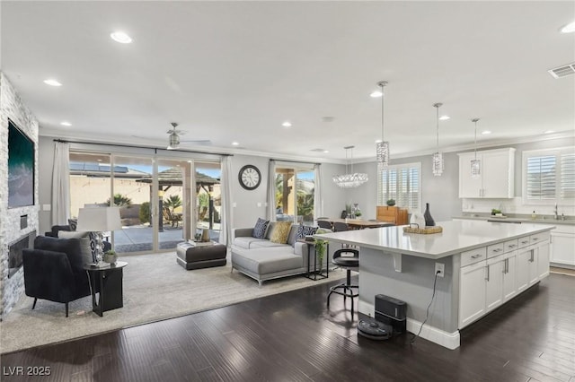 kitchen featuring pendant lighting, white cabinetry, a center island, and dark hardwood / wood-style flooring